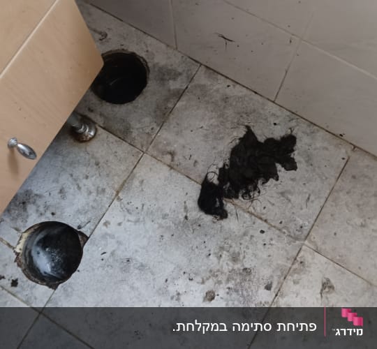 שני חורים ברצפה עם לכלוך ושיער